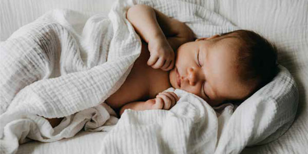 Bebé durmiendo envuelto en una manta