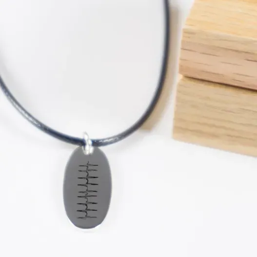 Colgante de plata ovalado grabado 'Latidos' (Detalle de presentación)