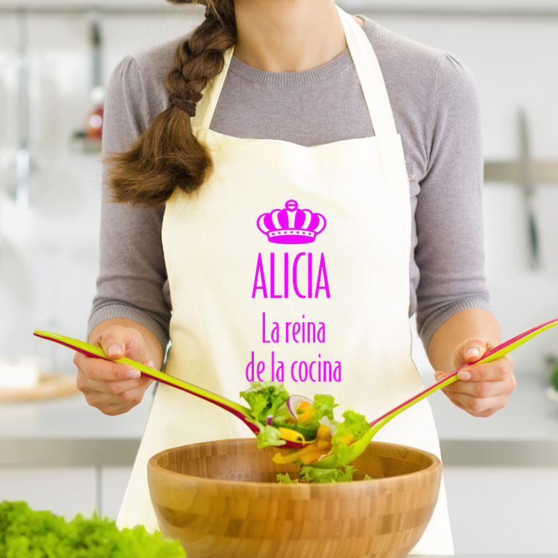 Una mujer con un delantal blanco se encuentra en una cocina.